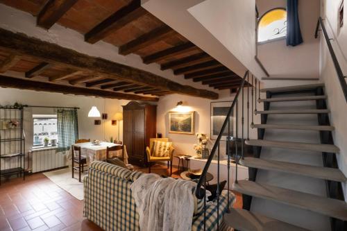 een woonkamer met een trap en een tafel bij La Colombaia in Massa e Cozzile