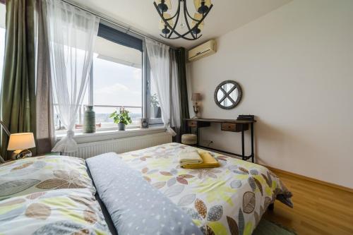 a bedroom with a bed and a large window at Comfy condo on the 20th floor & FREE parking in Bratislava