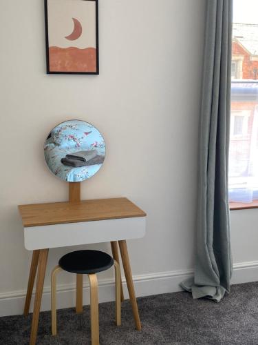 a desk with a stool next to a table with a globe on it at Comfortable 2 bedroom home from home with parking in Nottingham