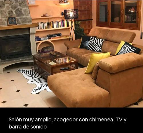 a living room with a couch and a fireplace at Increíble Casa Rural en la Sierra de Altomira Piscina privada y Barbacoa in Albalate de Zorita