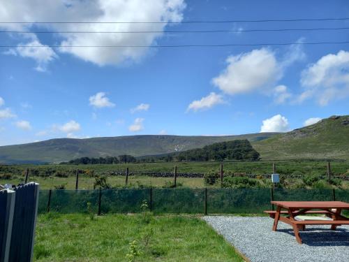 a picnic table and a view of the hills at OAKWOOD GLAMPING Mourne Mountains in Moyad