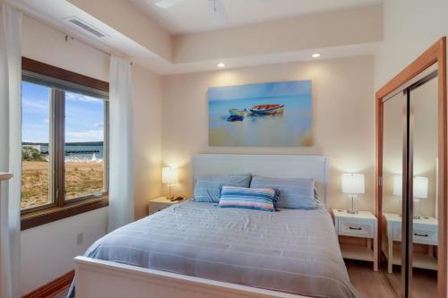 a bedroom with a bed and a large window at Sugar Beach Villa 1012 Luxury Waterfront Condo in Traverse City