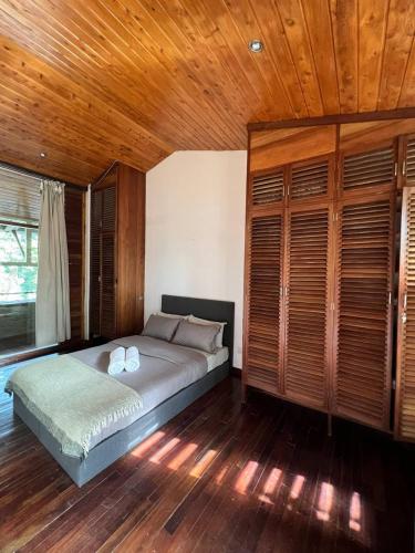 a bedroom with a bed and a wooden ceiling at Olosiva Oasis in Arusha