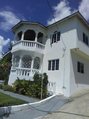 a white house with a balcony at The Retreat in Lyssons
