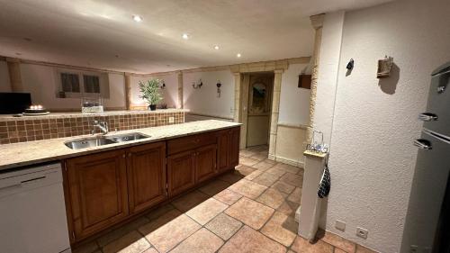 a large kitchen with a sink and a refrigerator at Le Havre de Paix in Boudevilliers