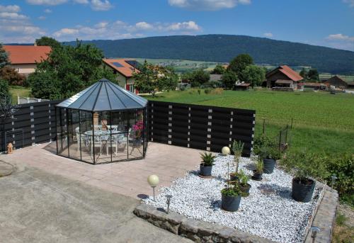 a gazebo with potted plants on a patio at Le Havre de Paix in Boudevilliers