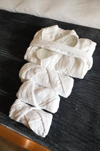 a group of white towels sitting on a bed at hOlarooms N2 in Tʼianetʼi