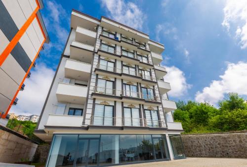 een hoog wit gebouw met glazen ramen bij ZAL SUİTE in Trabzon