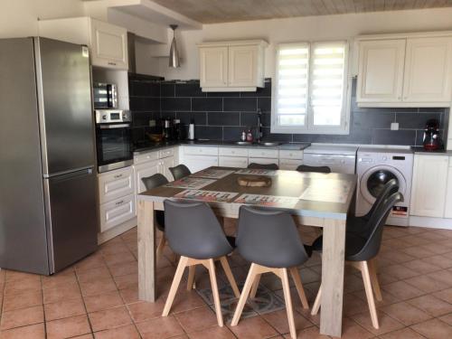 une cuisine avec une table en bois et des appareils noirs dans l'établissement Villa Roz Veur, à Crozon