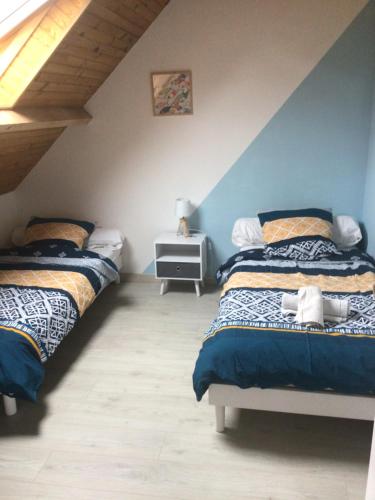 - une chambre avec 2 lits et un mur bleu et blanc dans l'établissement Villa Roz Veur, à Crozon