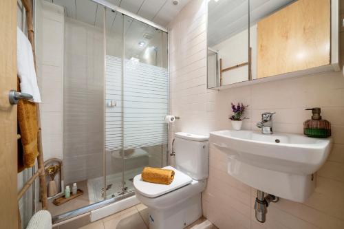 uma casa de banho com um WC, um lavatório e um chuveiro em 1ª LÍNEA DE PLAYA. Apartamento: LA CALMA em Comarruga