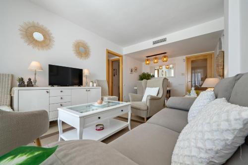 a living room with a couch and a tv at 1ª LÍNEA DE PLAYA. Apartamento: LA CALMA in Comarruga