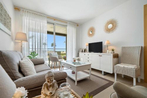 uma sala de estar com um sofá, uma mesa e uma televisão em 1ª LÍNEA DE PLAYA. Apartamento: LA CALMA em Comarruga