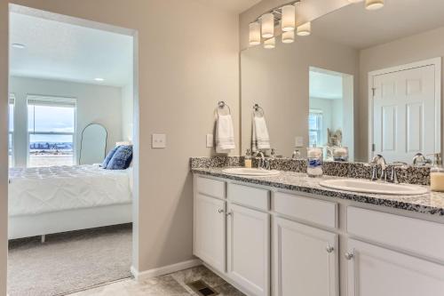 a bathroom with two sinks and a bedroom with a bed at Brand New Townhome with King Suite Near DIA in Denver