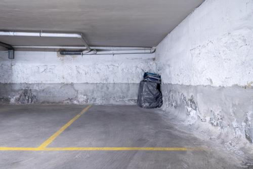 an empty parking garage with a trash bag in it at 1ª LÍNEA DE PLAYA. Apartamento: LA CALMA in Comarruga