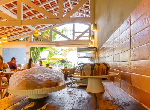 two chairs sitting on a wooden table in a restaurant at Pousada Vila Jacaa in Ubatuba