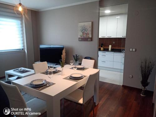 a dining room with a table and a kitchen at Suite XIMENA con piscina in Viveiro