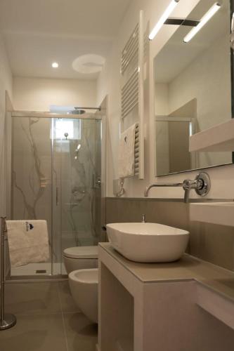 a bathroom with a sink and a toilet and a shower at suite la corte in Sannicandro di Bari
