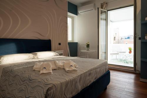 1 dormitorio con 1 cama con 2 toallas en suite la corte en Sannicandro di Bari