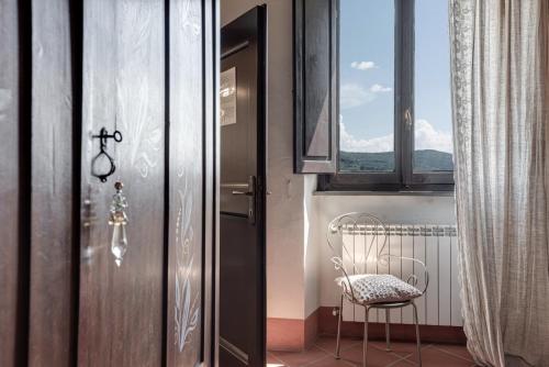 a chair sitting next to a door with a window at B&B Le Torri Di Firenze in Fiesole