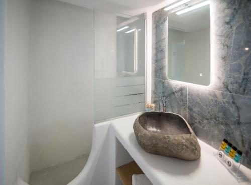 a bathroom with a large rock sink on a counter at Sarantis Suites & Apartments in Provatas