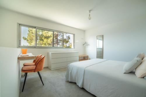 - une chambre blanche avec un lit, un bureau et une chaise dans l'établissement CASA LC VILLA 2-3 pers vue mer jacuzzi, à Ajaccio