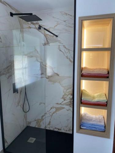 a shower with a glass door with folded towels at Casa de María in Muros