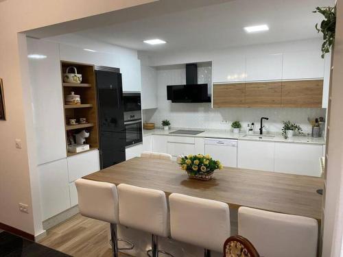 a kitchen with a wooden table and white cabinets at Casa de María in Muros