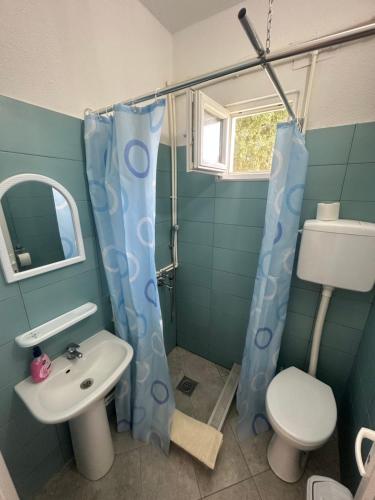 een badkamer met een wastafel, een toilet en een douche bij Apartments Frau Trena in Gevgelija