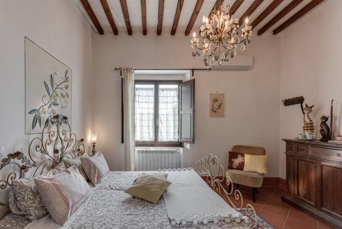 a bedroom with a bed and a chandelier at B&B Le Torri Di Firenze in Fiesole