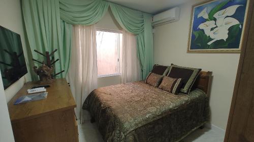 um pequeno quarto com uma cama e uma janela em Apartamento ótimo padrão volta redonda em Volta Redonda