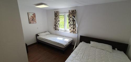 ein kleines Zimmer mit 2 Betten und einem Fenster in der Unterkunft Pod modrzewiem in Ostrzyce