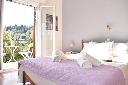 een slaapkamer met een paars bed en een groot raam bij Maison Anna Corfu Holiday Apartments in Ýpsos