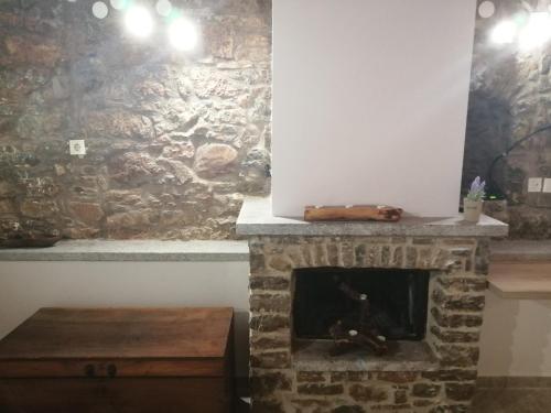 Una chimenea en una habitación con una pared de piedra. en ΑΝΑΒΑΤΟΣ ΕΞΟΧΙΚΗ ΚΑΤΟΙΚΙΑ, en Chios