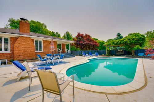 a swimming pool with chairs and a house at Charming Home with Pool and Deck about 9 Mi to UMich! in Ypsilanti