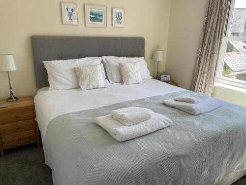a bedroom with a large bed with towels on it at Courtyard House, with parking and patio garden in Whitstable