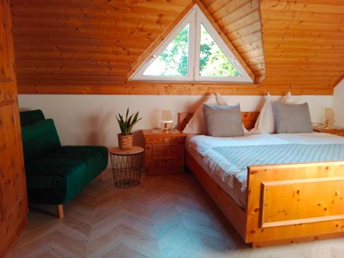 a bedroom with a bed and a window and a chair at Appartement Landhaus Felsenkeller in Sankt Kanzian