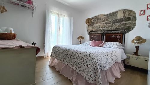 1 dormitorio con 1 cama grande y pared de piedra en Casa Vacanza Contado Latino, en Belmonte del Sannio