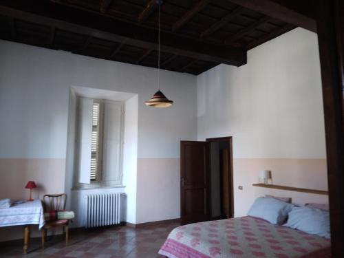 a bedroom with a bed and a table and a window at pietrolafontaine19 in Viterbo