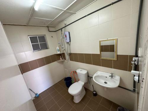 uma casa de banho com um WC e um lavatório em D'CAMERON MUSLIM HOMESTAY em Brinchang