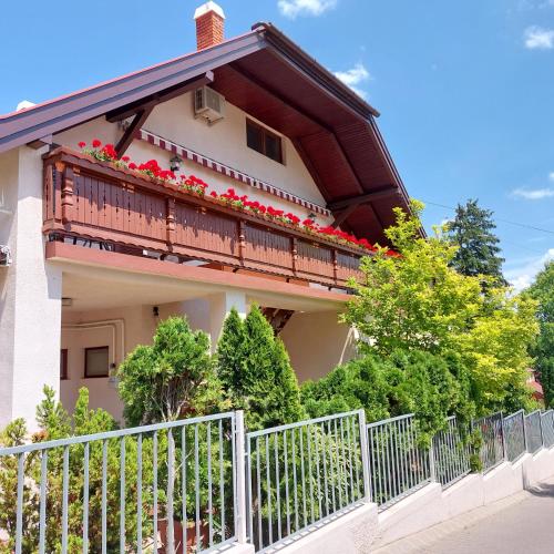 a house with a balcony with flowers on it at Erika Apartmanházak in Hévíz