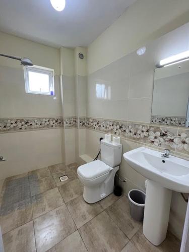 a bathroom with a toilet and a sink at Nitro Homes Nyali in Mombasa