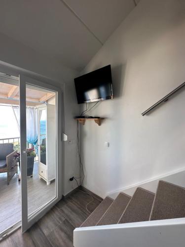 a living room with a flat screen tv on the wall at Tanis Ocean Loft in Martinšćica