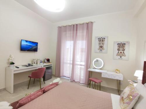 a bedroom with a bed and a desk with a computer at Siracusa Ortigia by Duomo in Siracusa