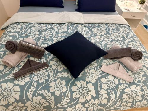a bed with a blanket and towels on it at Tanis Ocean Loft in Martinšćica