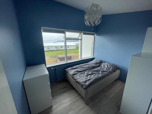 Habitación pequeña con cama y ventana en Heiðarbrún, en Hveragerði