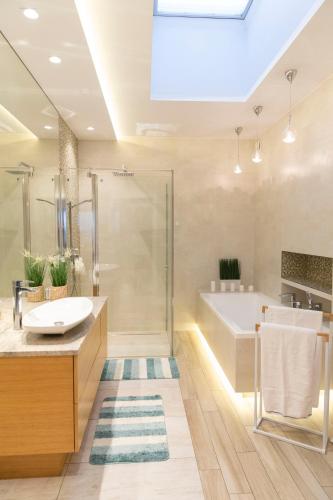 a bathroom with a sink and a shower and a tub at Apartament Termalny DELUX in Uniejow