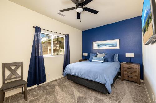 Schlafzimmer mit blauen Wänden und einem Bett mit Deckenventilator in der Unterkunft Mt. Elden Adventure in Flagstaff