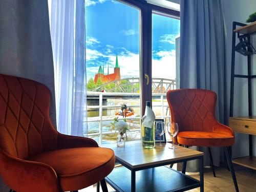 um quarto com duas cadeiras, uma mesa e uma janela em Great Polonia River Boat Apartments Wrocław em Breslávia