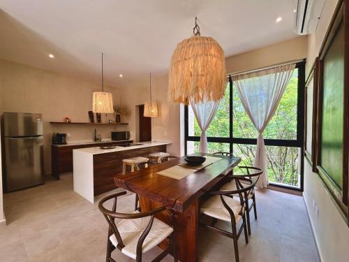 a kitchen with a wooden table and some chairs at TOH Tulum - 2 Bedroom Apartments - Fiber WiFi in Tulum